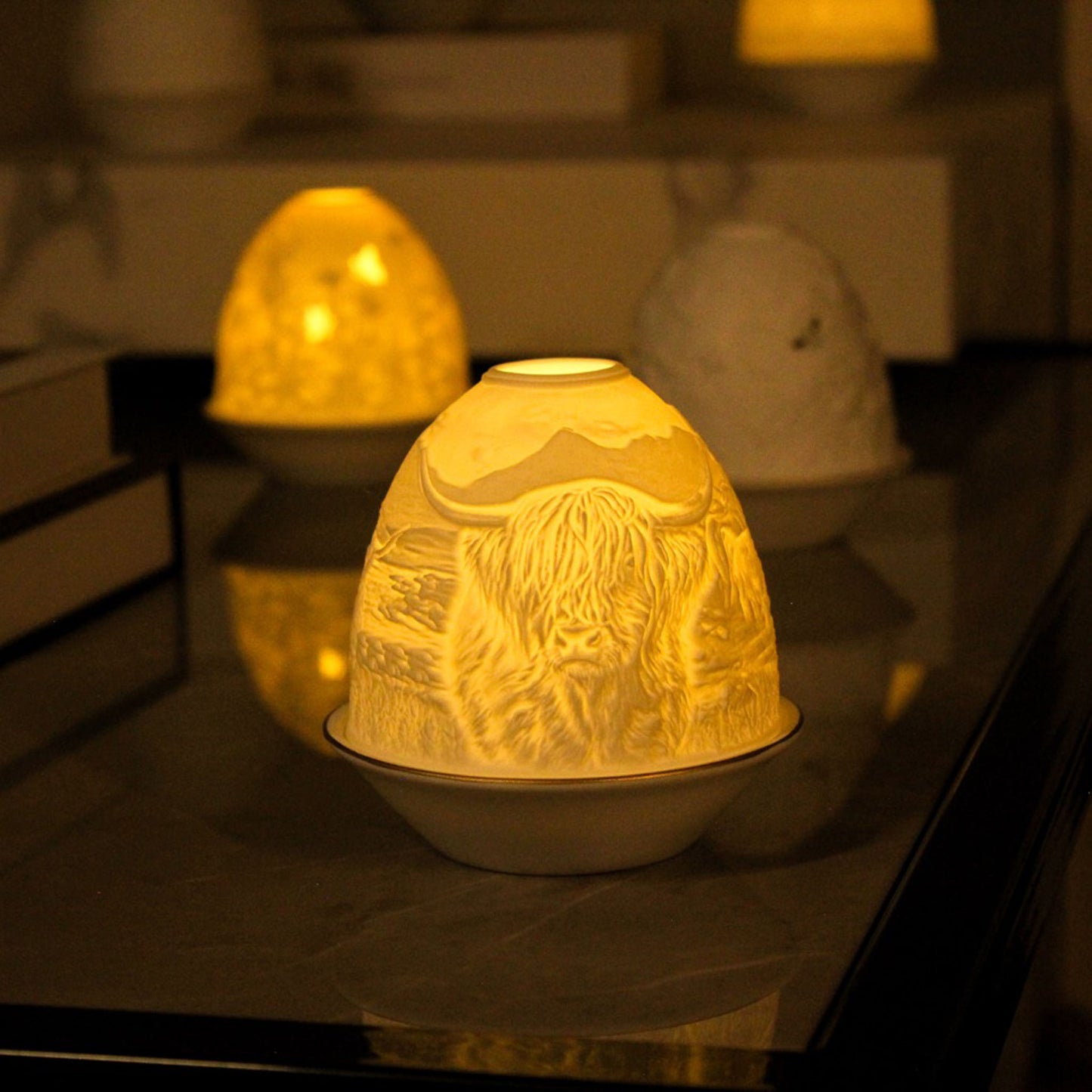 White porcelain tall dome candle holder with engraved Highland cow and gold rimmed plate lifestyle