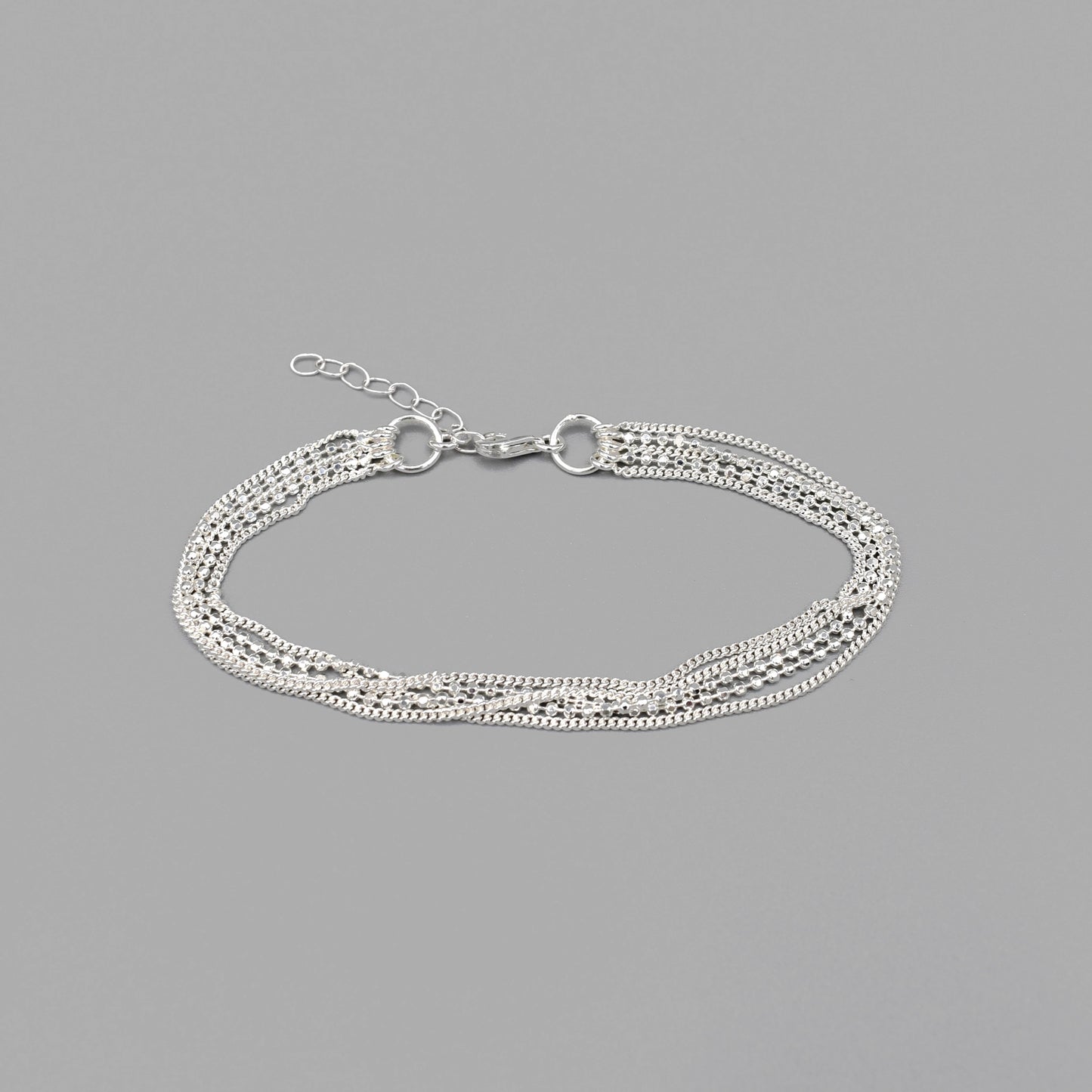 A sterling silver bracelet featuring three delicate silver chains and a double ball chain strand with lobster clasp
