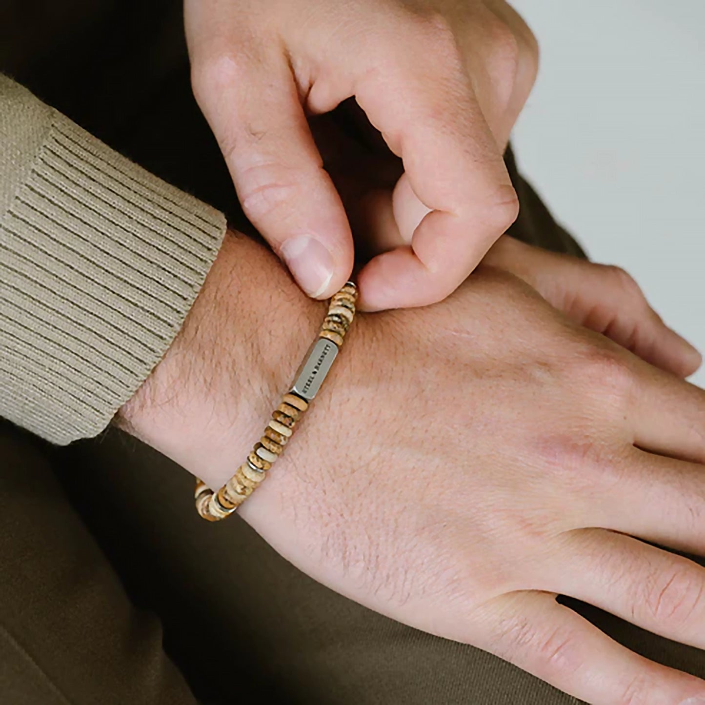 Model wearing a bracelet made from natural jasper stones cut into disc shapes