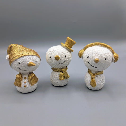 Three snowman ornaments with gold glitter, one with a Santa hat, one with a top hat and one with earmuffs 