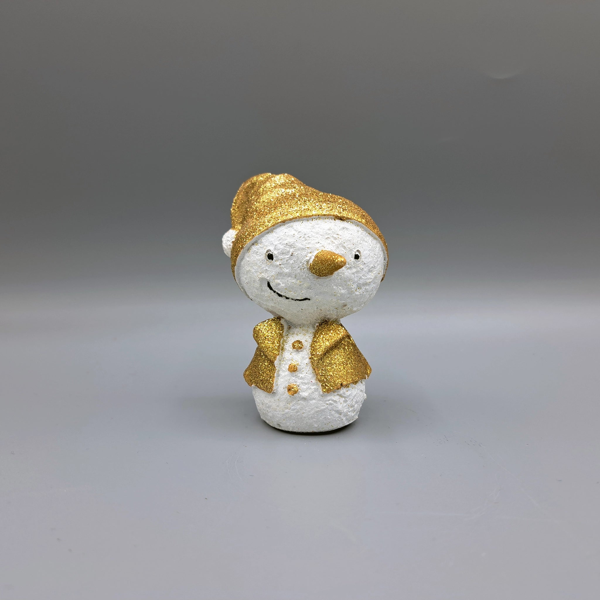 A snowman ornament with gold glitter details wearing a Santa hat and coat