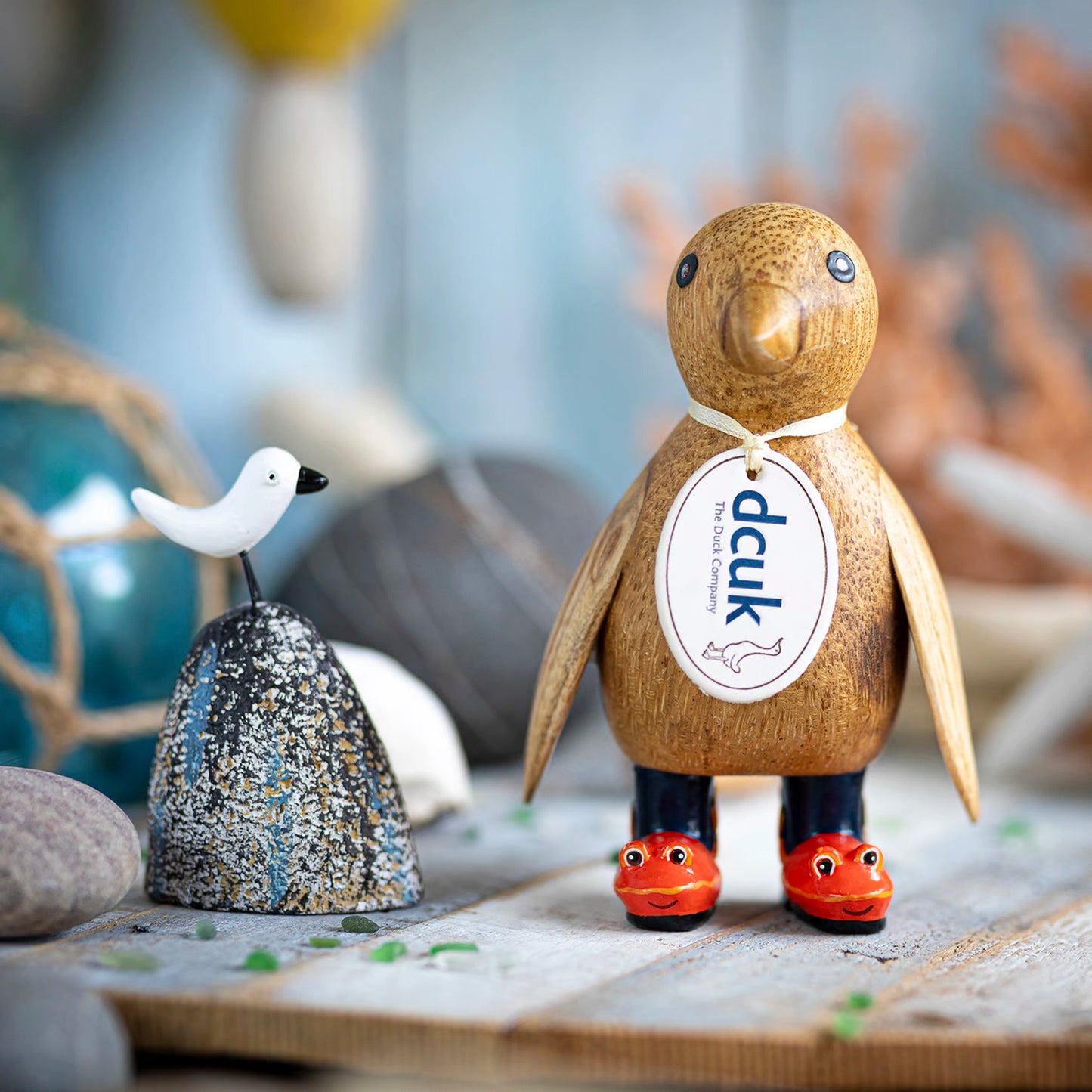 A wooden penguin wearing wellies with red crab design lifestyle