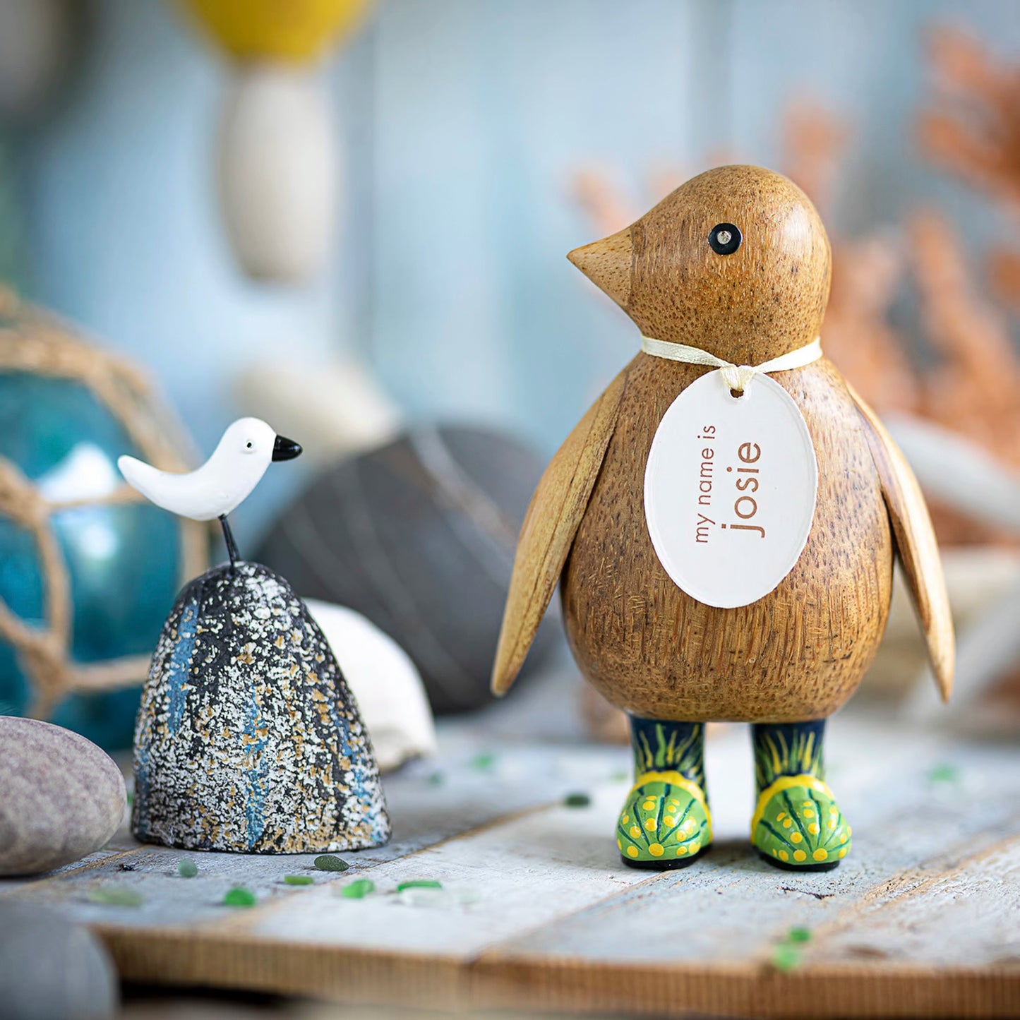 A wooden penguin wearing wellies with green jellyfish design lifestyle
