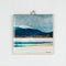 A ceramic tile featuring a seaside scene painting by Cath Waters