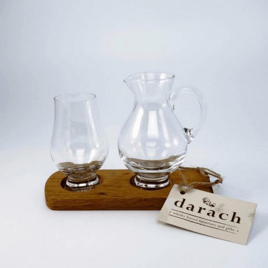 Single glass jug and nosing whisky glass on wooden barrel stave