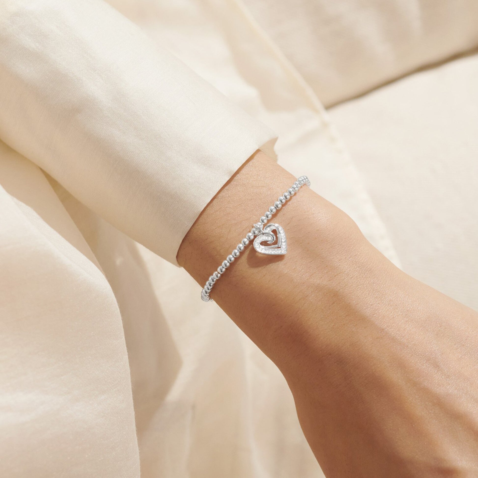 Silver bracelet with CZ heart charm on model
