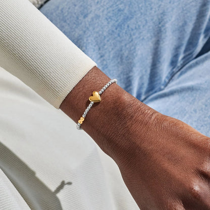 Model wearing silver beaded birth month bracelet for September with gold heart and infinity charms