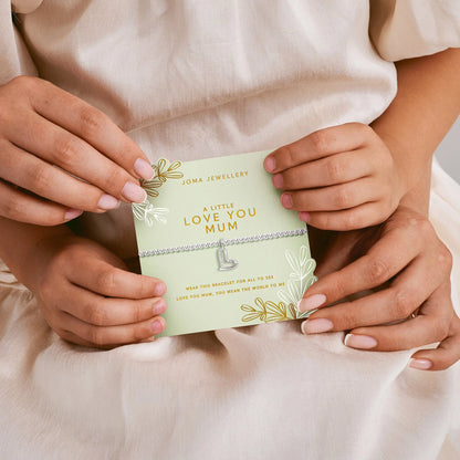 Silver beaded bracelet with CZ set open heart charm on green card held by mother and child