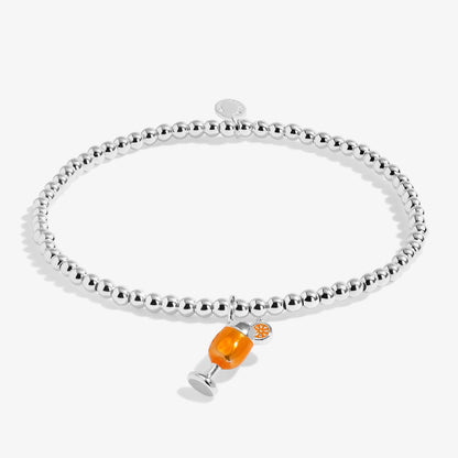 Silver beaded stretch bracelet with orange enamel cocktail drink charm