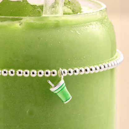 Silver beaded stretch bracelet with green enamelled matcha drink charm on a matcha drink