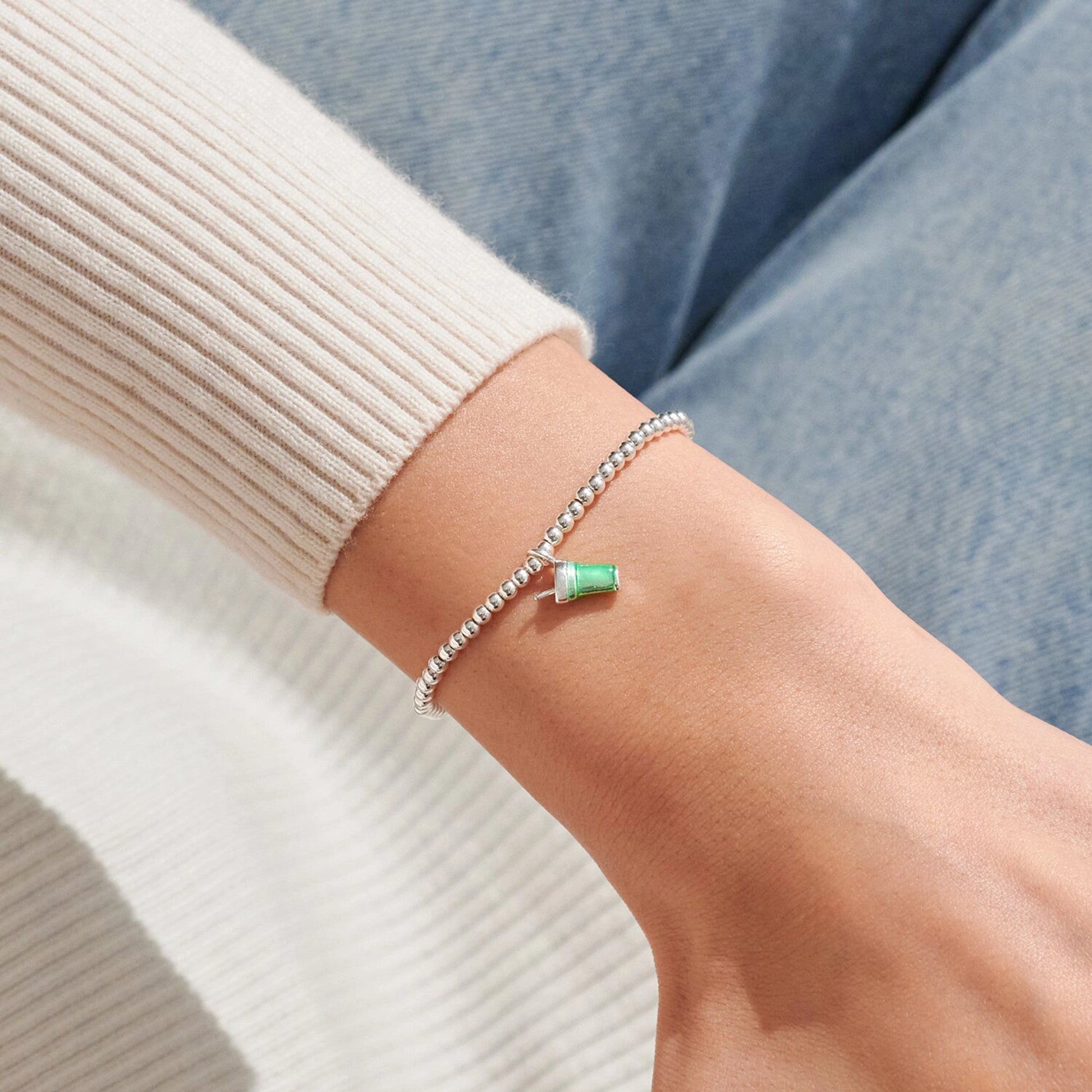 Model wearing silver beaded stretch bracelet with green enamel matcha drink charm