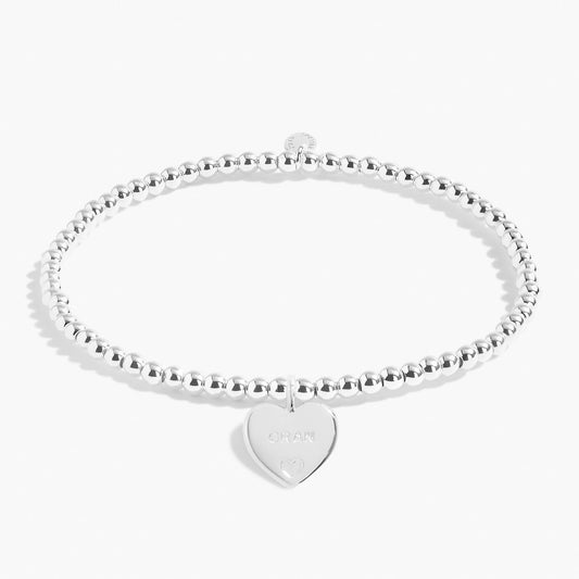 A silver beaded bracelet with a silver engraved heart 