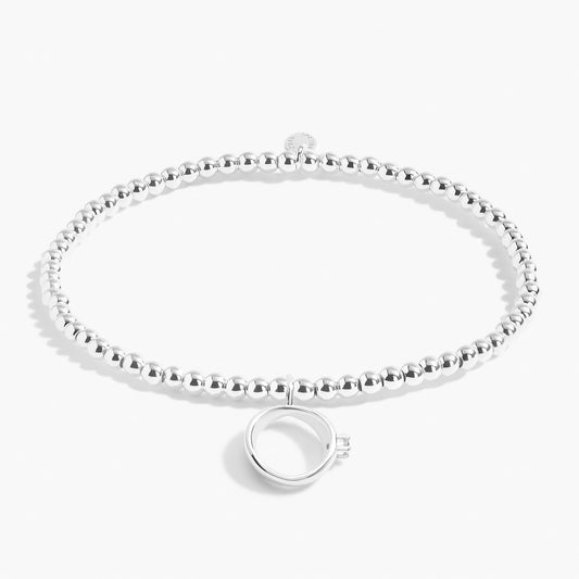 A silver beaded bracelet with a silver engagement ring with CZ stone
