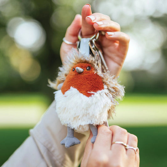 Model holding a plush robin keyring