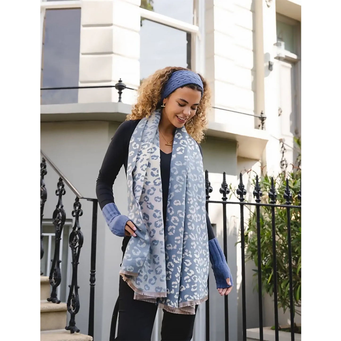 Model wearing denim blue animal print scarf with fringe