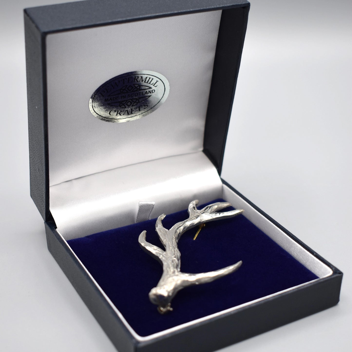 An antler shaped pewter kilt pin in box