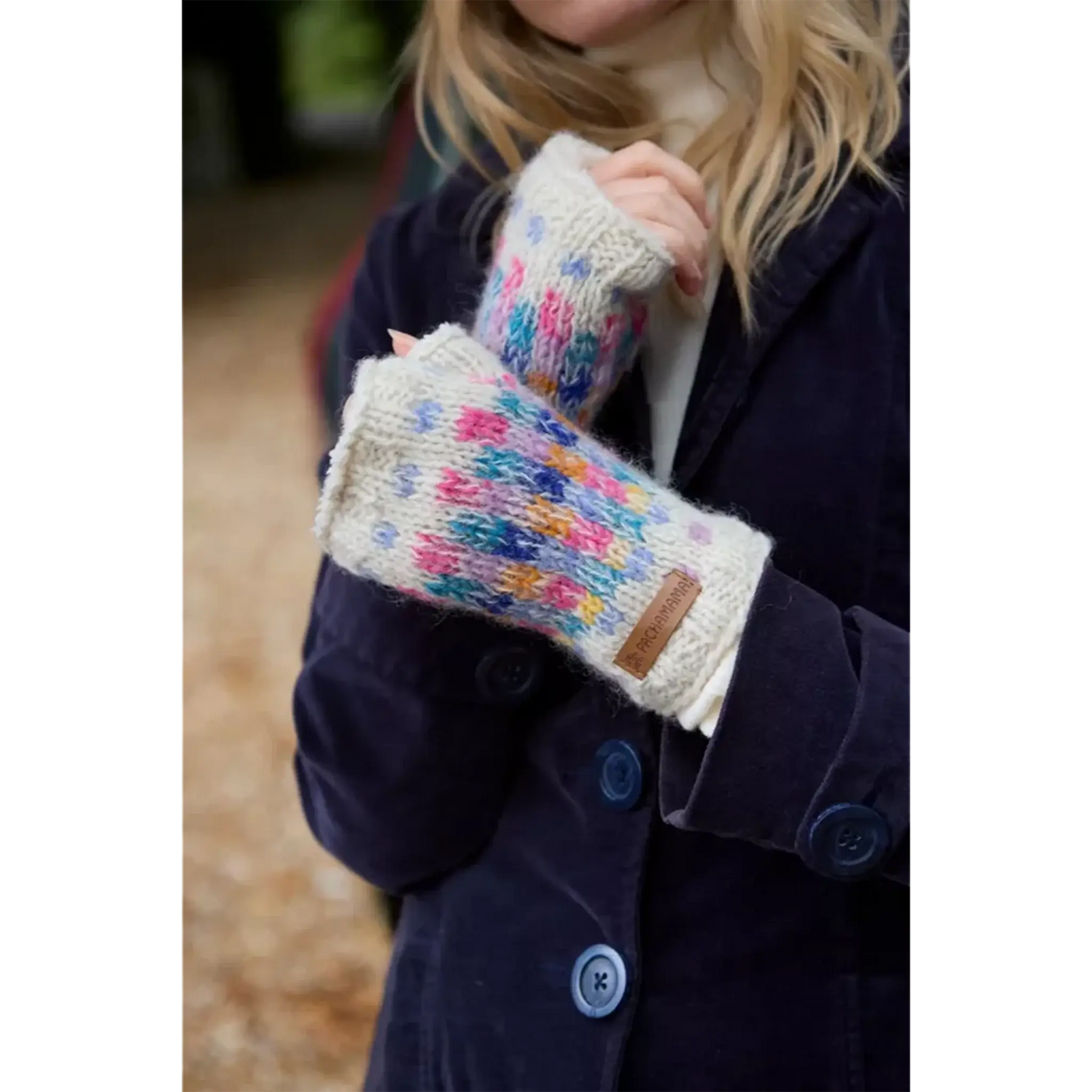 Model wearing oatmeal handwarmers with rainbow pastel check pattern