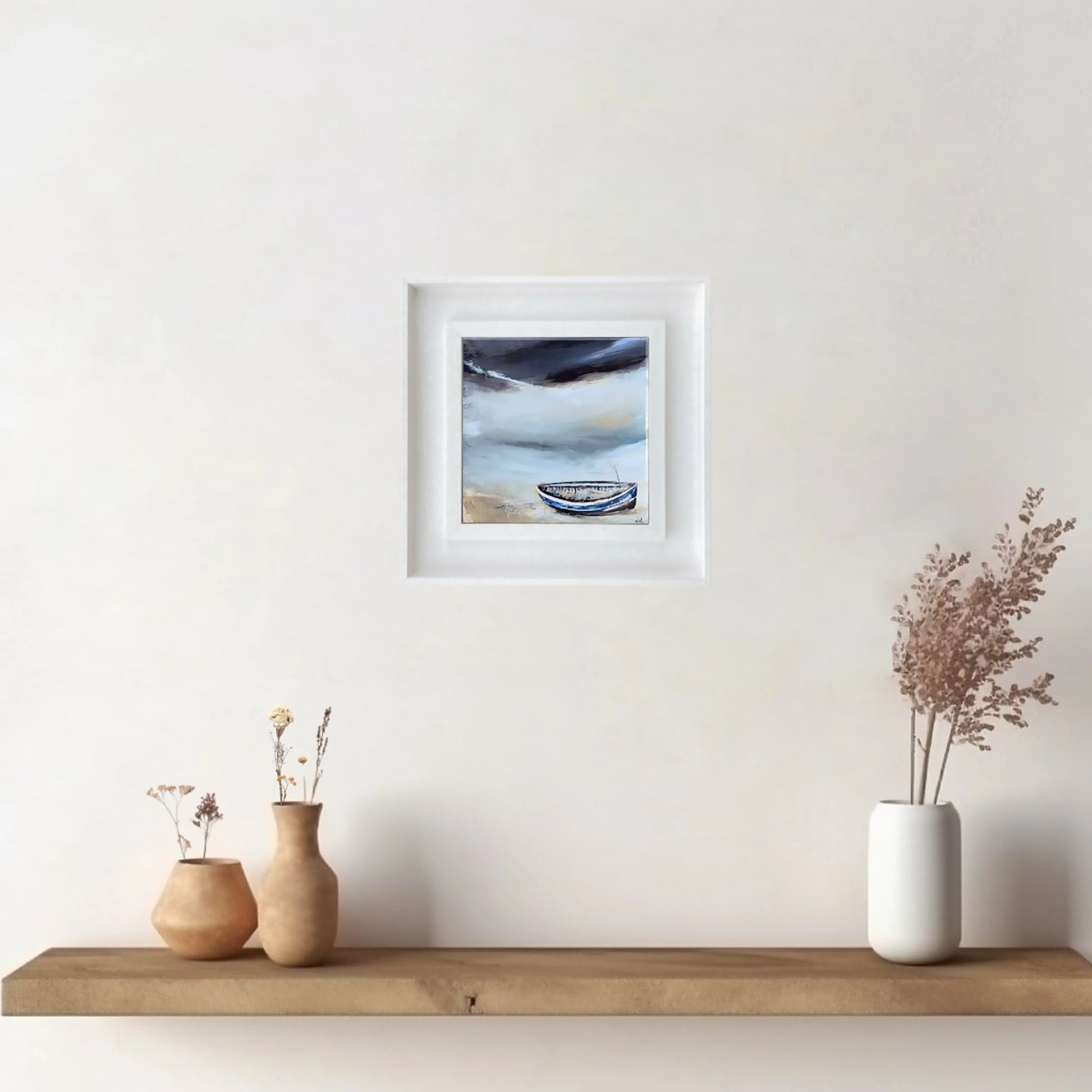 A ceramic tile printed with an abstract painting of a boat on a shoreline mounted on a white frame hanging