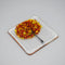 A clear glass square coaster with a yellow & red tree design