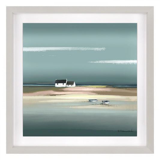 Square framed print of a seaside scene with blue sky and water and a white cottage on a bright sandy shoreline.