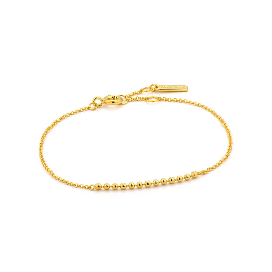 A gold chain bracelet featuring a bar of linked small balls and an adjustable circle clasp closure