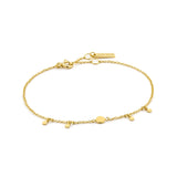 Gold chain bracelet featuring four small disc shaped drops, one larger drop link and an adjustable round clasp closure