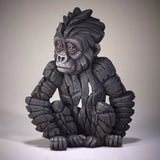 A textured and painted sitting baby gorilla sculpture side view