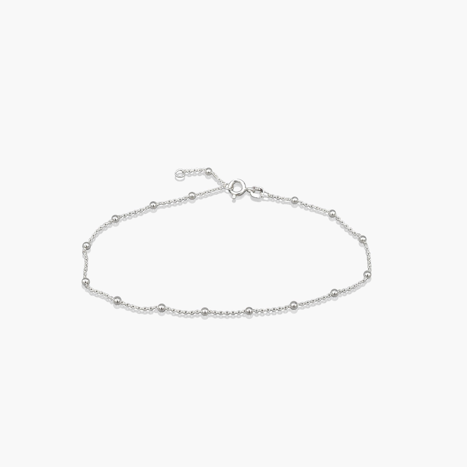 A silver chain anklet with silver ball details