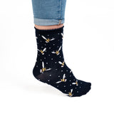 Model wearing a pair of navy blue socks with a bumblebee picture and white polka dots