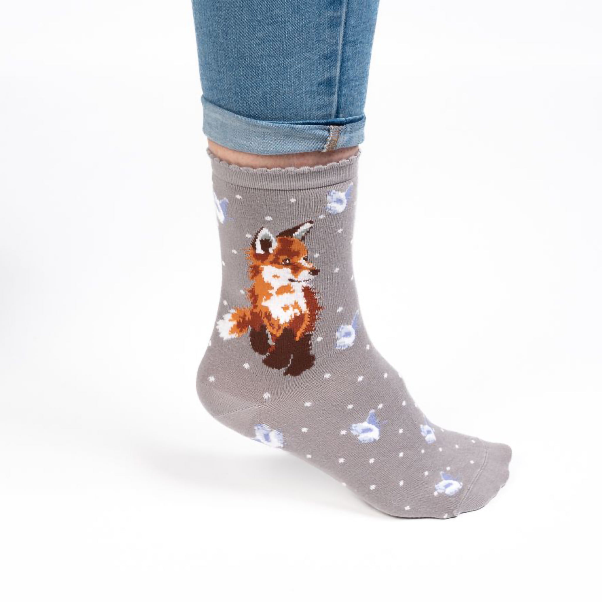 Model wearing a pair of warm grey socks with a little baby fox cub picture and white polka dots
