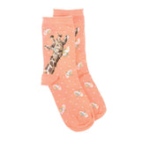 A pair of coral pink socks with a giraffe and daisies picture and white polka dots