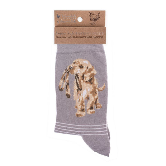 A folded pair of warm grey socks with a golden lab puppy picture and white stripes