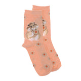 A pair of pink socks with a hamster and jam filled biscuits picture and white polka dots