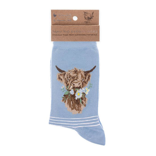 Folded pair of light blue socks with a highland cow picture and white stripes