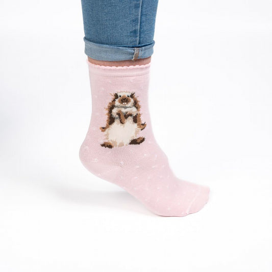 Model wearing a pair of light pink socks with a rabbit picture and white polka dots