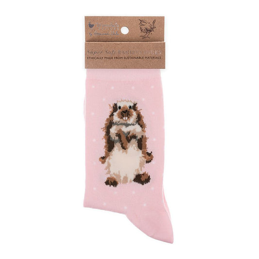 Folded pair of light pink socks with a rabbit picture and white polka dots