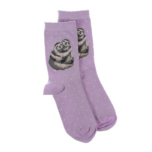 A pair of purple socks with a picture of two cuddling sloths and white polka dots