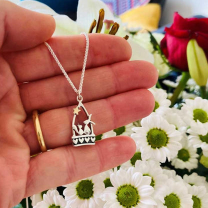 A silver stirrup pendant with a little hare and squirrel, heart details and a gold star lifestyle