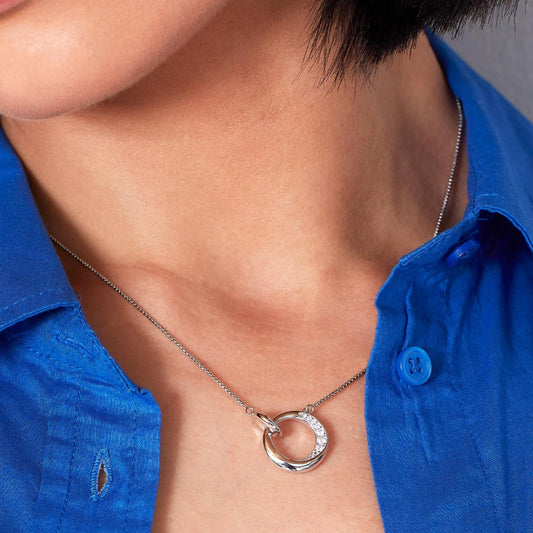 Model wearing a silver necklace with CZ bevelled open circle and smaller linked circle