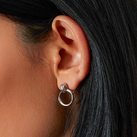 Model wearing a pair of silver loop drop earrings with double loop bails