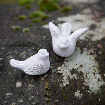 A pair of grey concrete bird figurines, ones with open wings and one with closed wings - lifestyle