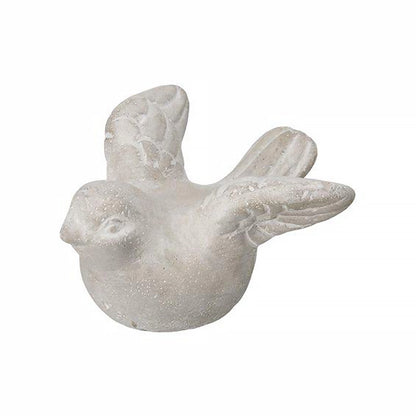 A grey concrete bird figurine with open wings