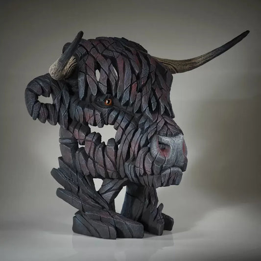 A textured and painted black Highland cow head bust sculpture from the side