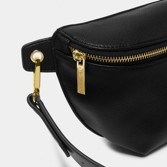 Close-up of gold hardware on black faux leather belt bag