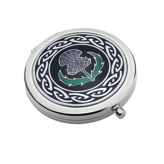 A silver compact mirror with enamelled top featuring a Celtic frame with purple and green thistle