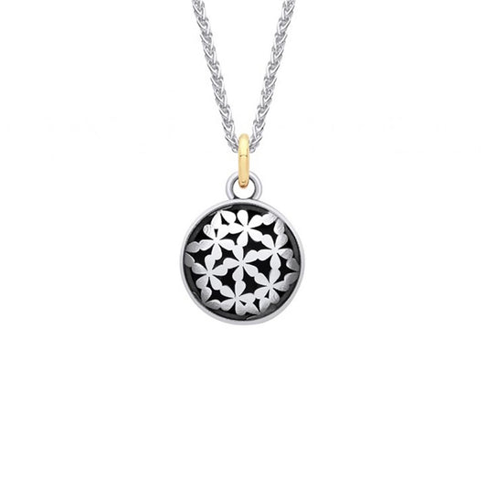 Silver coin shaped pendant with tiny flower design and oxidisation with a gold bail on a silver chain