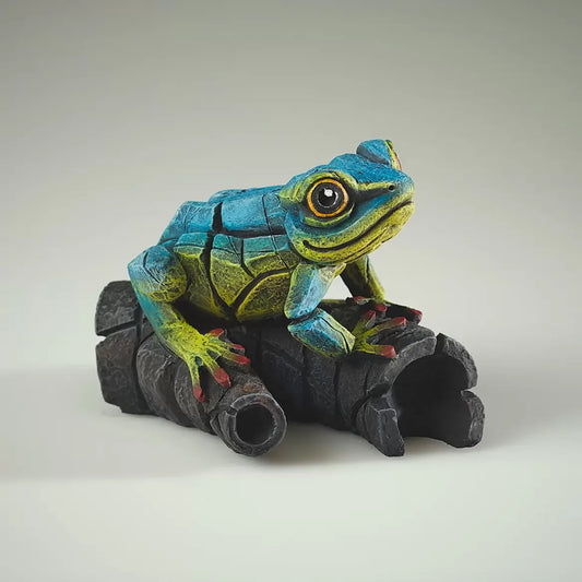 A textured and painted blue and yellow tree frog on log sculpture from side
