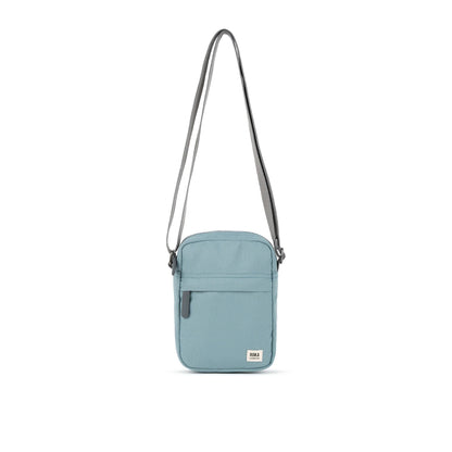 A small crossbody bag in canvas material and a light blue colour