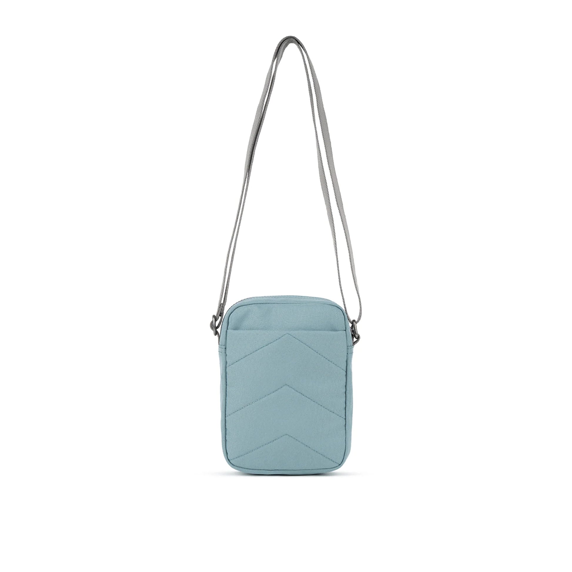 A small crossbody bag in canvas material and a light blue colour back