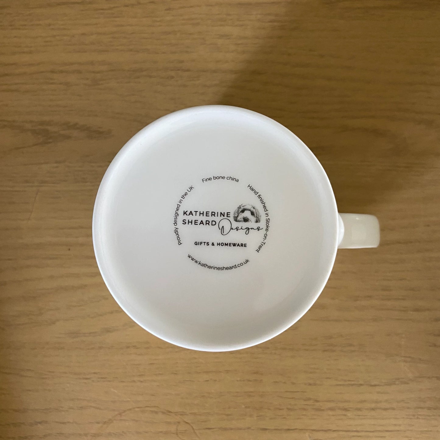 Bottom of white mug with Katherine Sheard Designs Logo